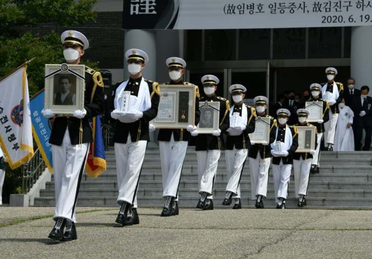 South Korean honour guards carry portraits and urns of compatriot soldiers killed during the 1950-53 Korean War, during a burial ceremony at the National Cemetery in Daejeon