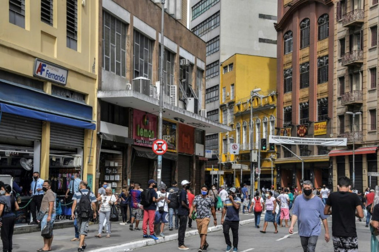 People walk down a commercial street in Rio de Janeiro after its reopening June 10, 2020