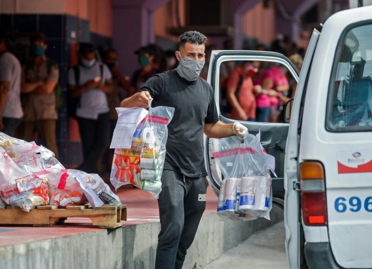 A worker loads online purchases on a van to be delivered, outside a pick up center in Havana, on June 17, 2020