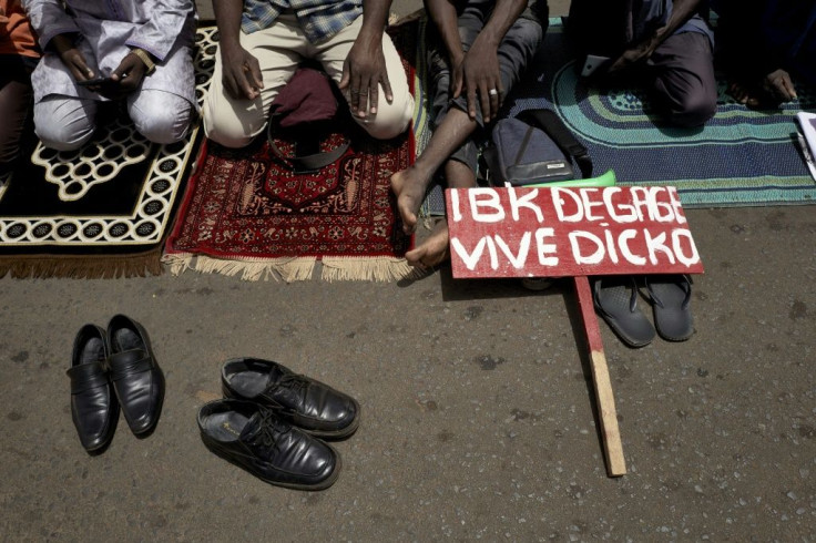 Muslim protesters pray in Independence Square. The placard reads 'IBK out, long live Dicko,' referring to President Ibrahim Boubacar Keita and Imam Mahmoud Dicko, who has risen to challenge him