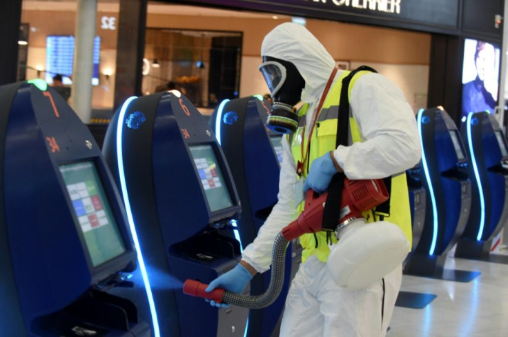 An operator disinfects self-service check-in kiosks at Orly 3 terminal's departure hall on the day Paris-Orly airport reopened.