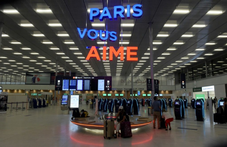 Passengers wait by self-service check-in kiosks at Orly 3 terminal on the day of the re-opening of Paris' Orly airport. They are greeted with the words "Paris Vous Aime," or "Paris Loves You."