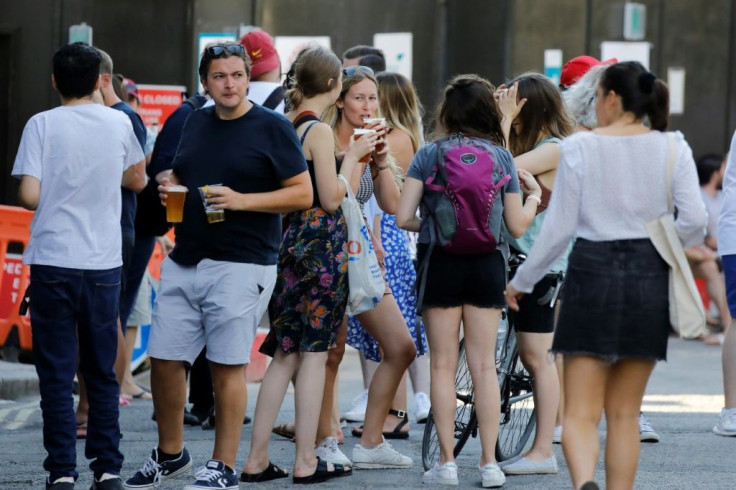 People relax with takeaway beer in plastic cups -- and not much social distancing -- at Borough Market in London