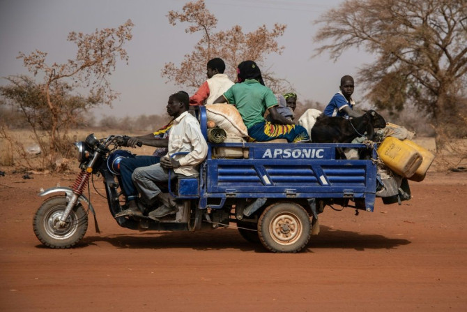 People flee with their belongings after a jihadist attack in rural northern Burkina Faso in April. Nearly a million people have been displaced