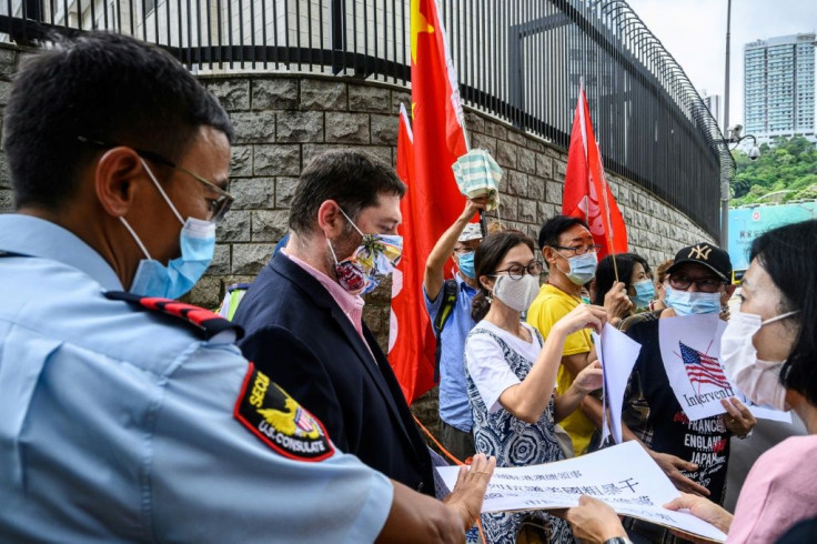 Pro-China activists holding placards and flags hand over a petition at the US consulate general in Hong Kong -- Washington has now imposed visa restrictions on Chinese officials over curbs on the city's autonomy