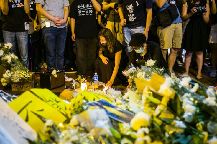 Pro-democracy activists in Hong Kong pay their respects in June 2020 to mark the one-year anniversary of the death of a man who took a fatal fall after hanging a banner against a now-withdrawn extradition bill that sparked mass protests