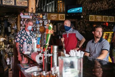 Patrons, some wearing masks and some not, sit at a bar in Austin, Texas, on June 26, 2020, as Governor Greg Abbott said he had allowed bars to reopen too soon