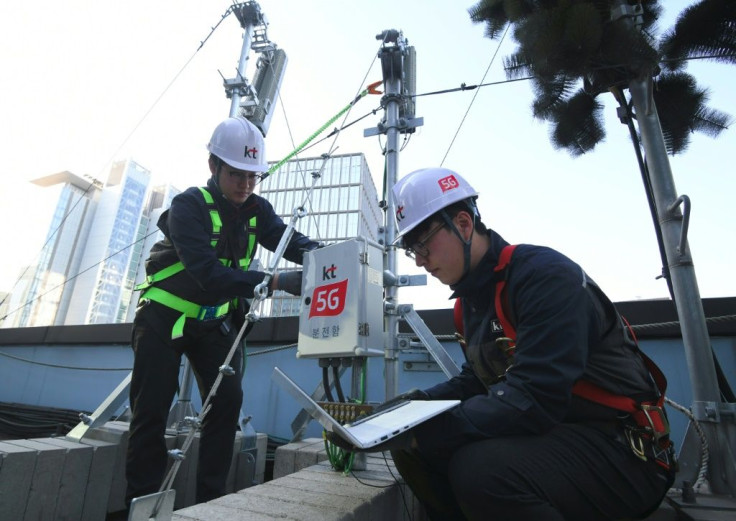 Technicians of South Korean telecom operator KT check an antenna for the 5G mobile network service in Seoul