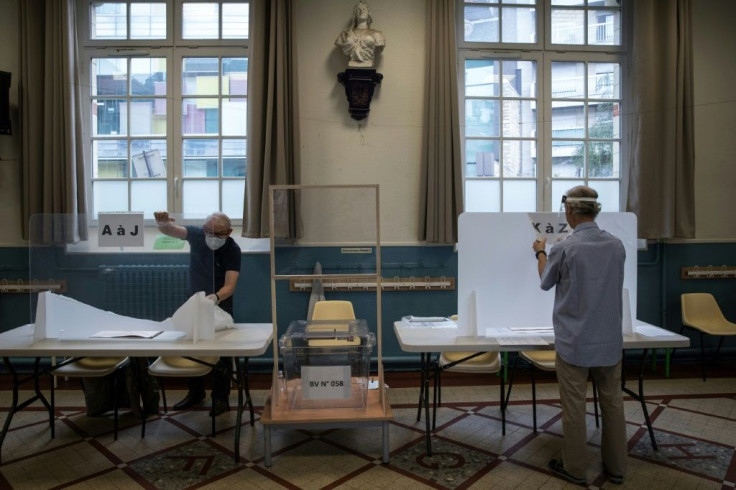 Plexi-glass protections against coronavirus are installed in a polling station before French local polls which seem set to deliver a rebuke to President Macron's party