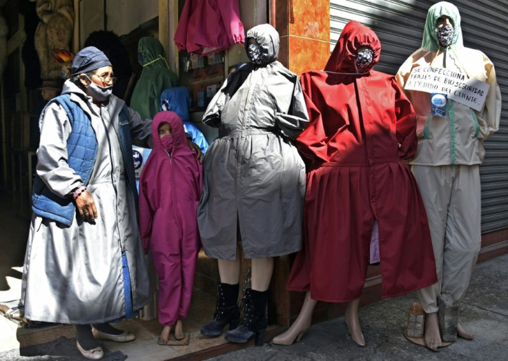 A woman stands next to protective suits designed for âcholitasâ (indigenous women who wear typical skirts) outside a store in La Paz, Bolivia