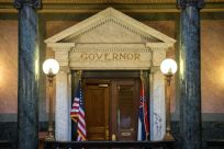 The Mississippi state flag (R) is seen outside the governor's office at the state capitol building in Jackson, Mississippi -- Governor Tate Reeves has said he will sign the bill to change the flag into law