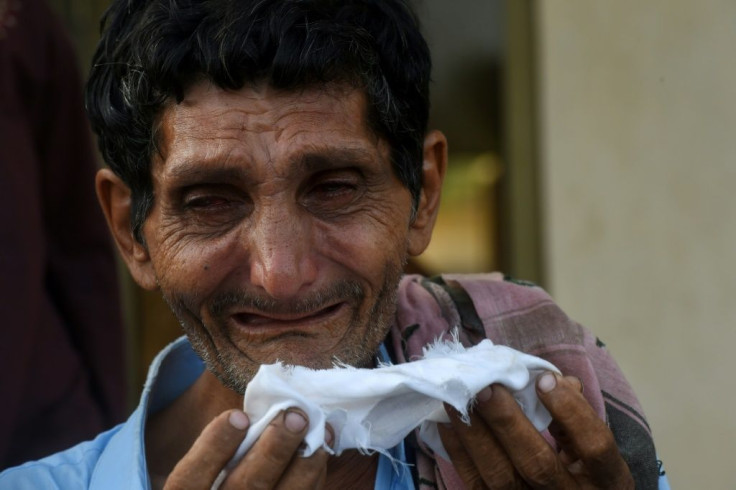 A private security guard's elder brother mourns his death during the funeral in Karachi -- the guard was one of four people killed by gunmen