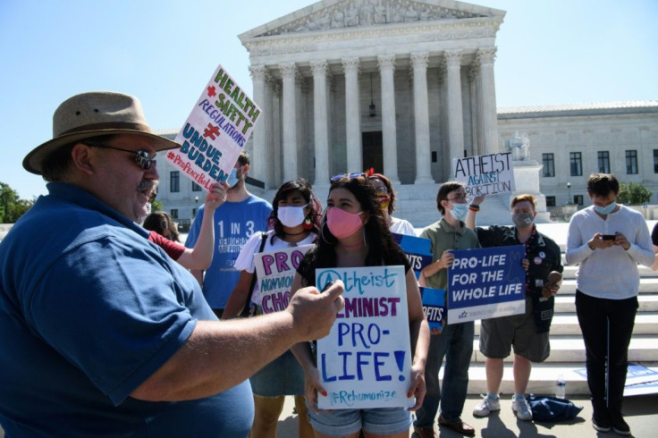 An anti-abortion activist reads to others the US Supreme Court's decision on a Louisiana law restricting abortion in Washington, DC, on June 29, 2020