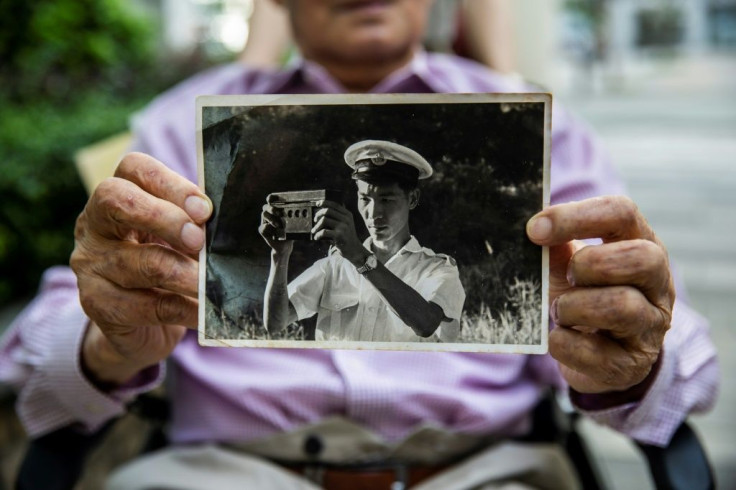 Lau holds a picture of himself from when he worked at Hong Kong's Water Supplies Department