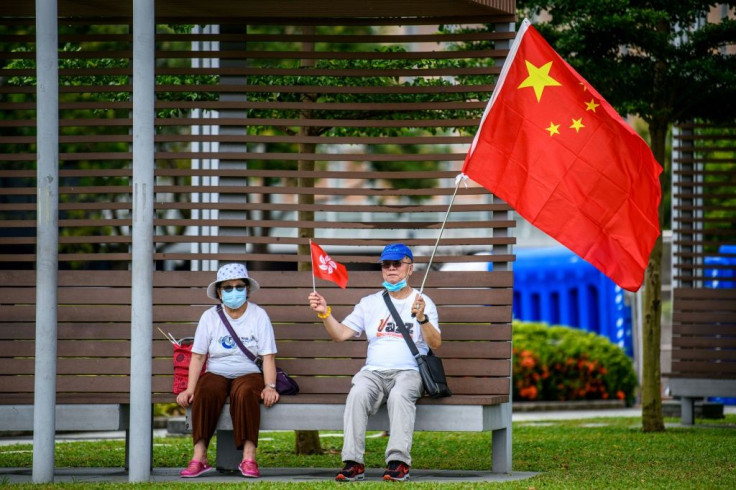 Pro-China supporters display Chinese and Hong Kong flags on the sidelines of a rally near the government headquarters in Hong Kong