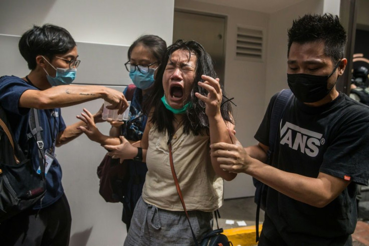 A woman reacts after being hit by pepper spray as police tried to stop protests in Hong Kong