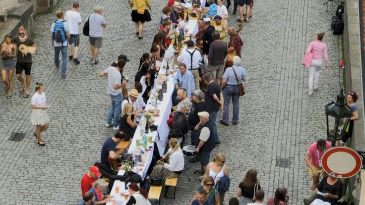 Crowds of people in Prague gather for dinner at a 500-metre-long table to celebrate the end of the coronavirus crisis in the country. They have brought their own food and drinks which they share with their fellow diners on Prague's historic Charles Bridge