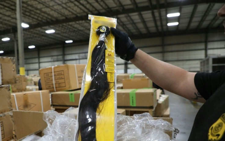 A US Customs and Border Protection officer at the Port of New York/Newark inspects a shipment of hair pieces and accessories from China suspected to have been made with forced or prison labor