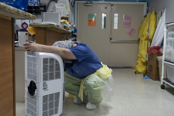 A medical worker rests in front of a fan in the COVID-19 intensive care unit at United Memorial Medical Center in Houston, Texas