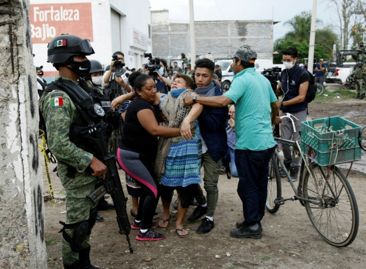 A woman reacts near the crime scene where 24 people were killed in Irapuato, Guanajuato state, Mexico