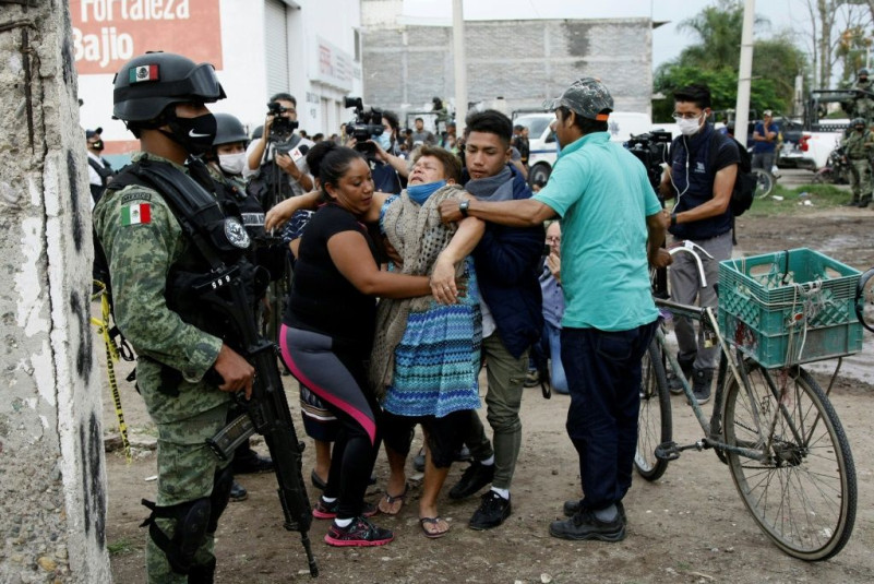 A woman reacts near the crime scene where 24 people were killed in Irapuato, Guanajuato state, Mexico