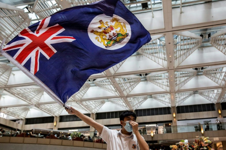 A protester waves the former British colonial Hong Kong flag at arally in a shopping mall. A new Chinese security law imposed on the city is causing fresh tension between London and Beijing