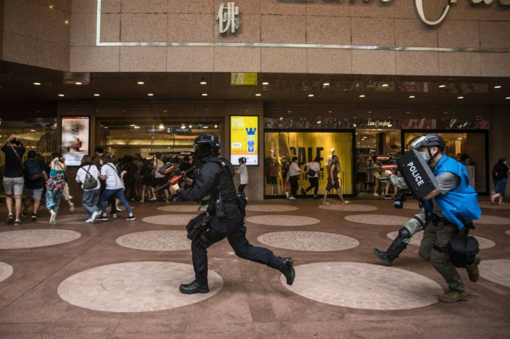 Riot police clear people and protesters gathered on a road during a rally against a new national security law in Hong Kong