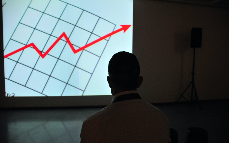 Man wearing white top at projector graph screen