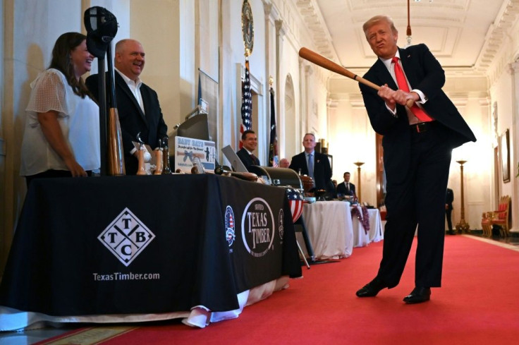 US President Donald Trump takes a swing with a bat from Texas Timber at a Spirit of America event at the White House to showcase small businesses -- he insists the US economy is "roaring back" from the coronavirus crisis