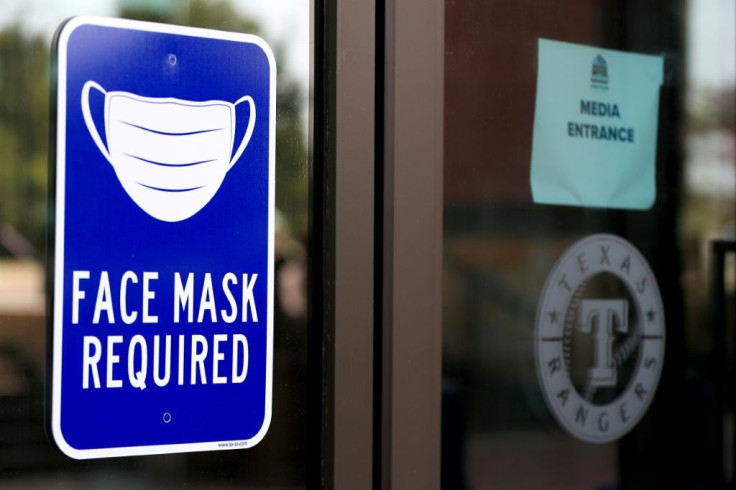 A face mask sign on the door is the first thing visitors to the Texas Rangers training facility in Dallas see as they enter Globe Life Field.