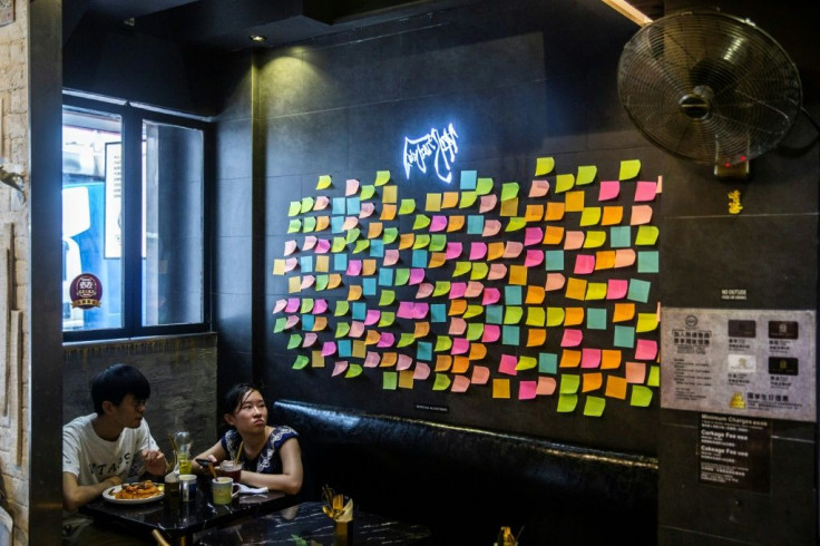 Customers sit near notes deliberately left blank on a âLennon Wallâ inside a pro-democracy restaurant in Hong Kong