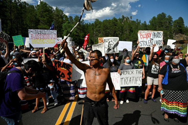 Activists and members of different tribes block a road near Mount Rushmore as they protest the US government in Keystone, South Dakota on July 3, 2020, ahead of a visit by President Donald Trump