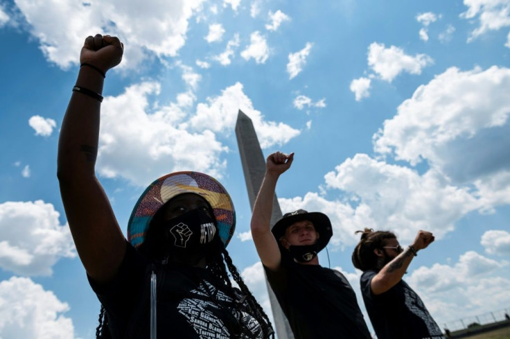 Protesters raise their fists during a rally against racism in front of the Washington Monument on July 4, 2020, a national holiday darkened by the coronavirus pandemic, continuing racial tensions and angry words from President Donald Trump