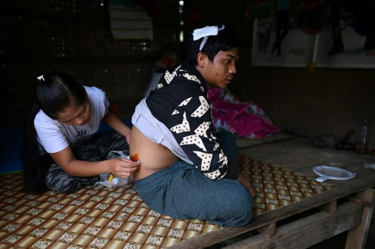 Pan Ei Phyu treats the wounds of husband Sai Ko, who survived the deadly landslide