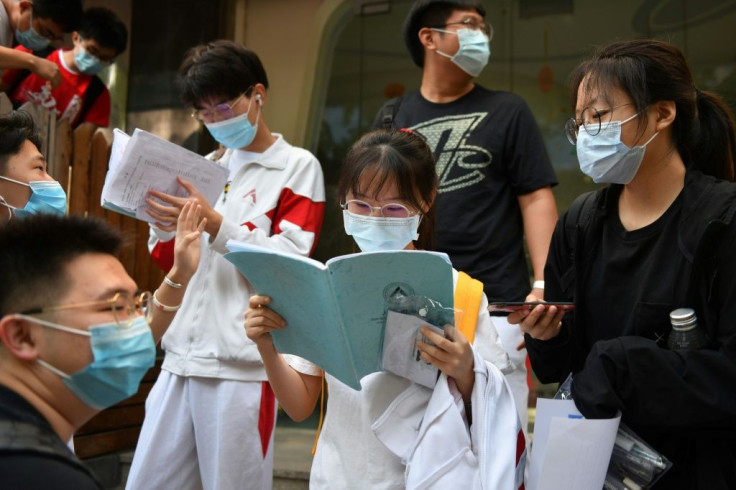 Students get in some last minute study outside a school before entering to sit the National College Entrance Examination (NCEE), known as Gaokao, in Beijing