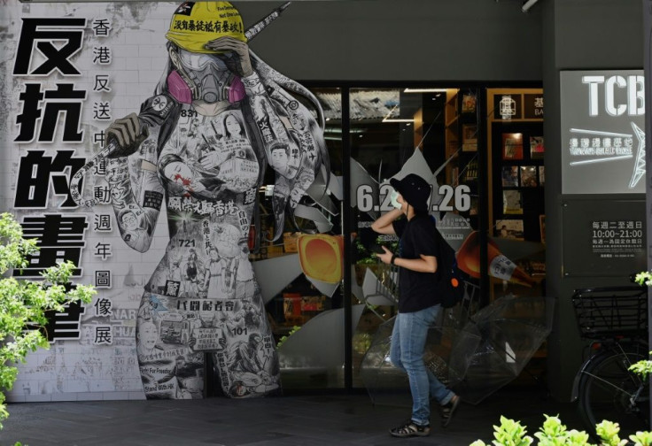 A woman in Taipei walks past a billboard promoting democracy for Hong Kong