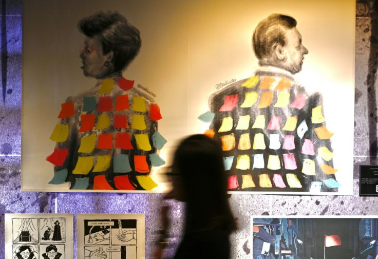 A woman walks past a painting at an exhibition about Hong Kong's protests in Taipei