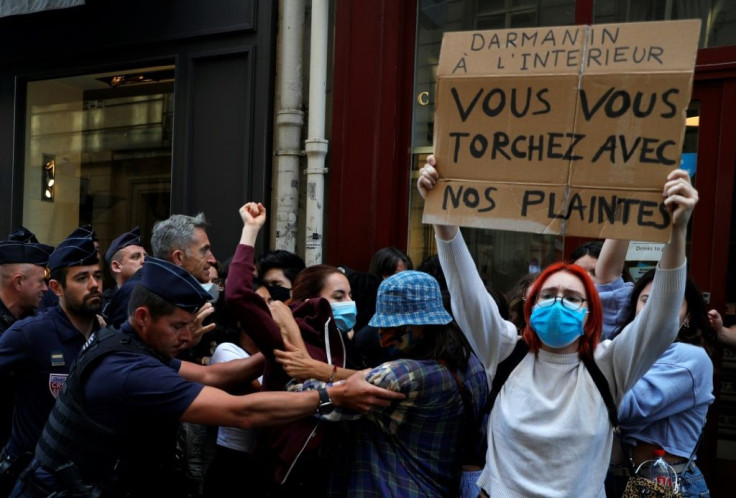 French riot police block feminist protesters holding banners against Gerald Darmanin, who has been appointed interior minister despite the reopening last year of an investigation into rape allegations against him dating from 2009