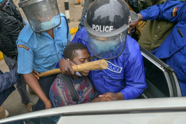 A protestor is pushed into a vehicle after being arrested