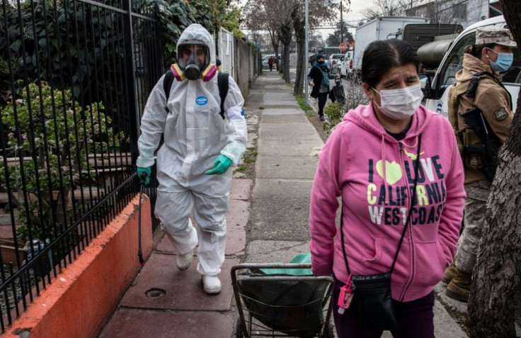 A municipal worker cleans and disinfects the streets of San Miguel neighbourhood in Santiago