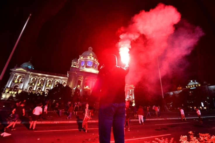 Demonstrators lit flares and were seen throwing stones at police in the Serbian capital
