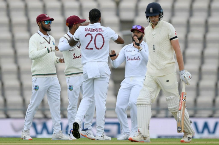 West Indies players celebrate after taking the wicket of England's Dom Sibley