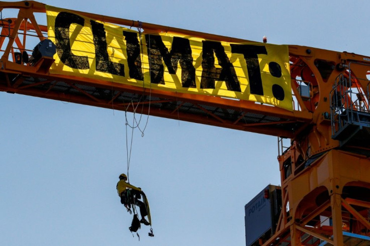 A Greenpeace activist stages a protest on a crane at the Notre-Dame building site