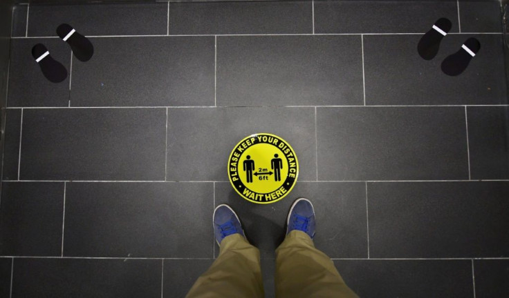 Foot markings and a coronavirus social distance reminder are seen on the floor of an elevator in an office building in Hollywood, California on July 7, 2020