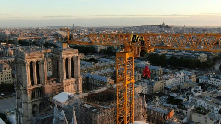 Greenpeace unfurls a large banner on a crane overlooking Notre Dame Cathedral in Paris demanding the French government takes "action" on the issue of climate change.