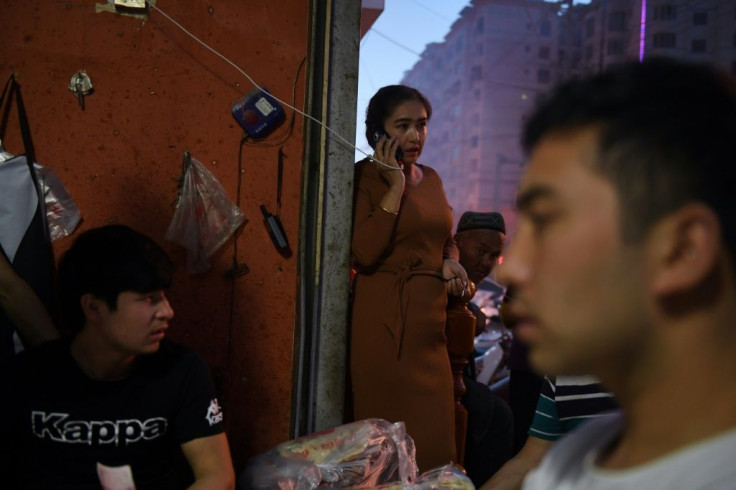A woman uses a mobile phone outside a restaurant in Hotan in China's northwestern Xinjiang region in 2019