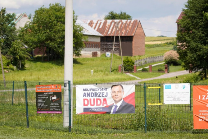 A campaign poster bearing a portrait of President Duda is displayed on a fence in Godziszow, a bedrock of his conservative administration