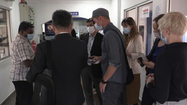 Al Jazeera journalists arrive at Malaysia's national police headquarters for questioning on a documentary about the arrests of migrants during the coronavirus lockdown.