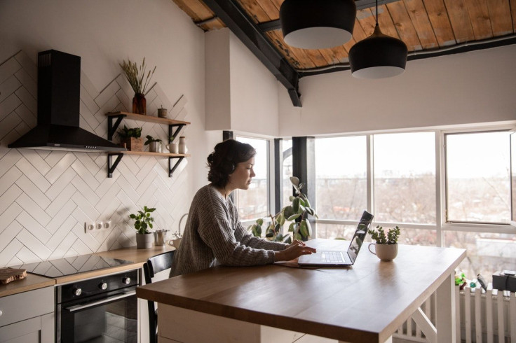 young-woman-surfing-laptop-in-kitchen-4049990