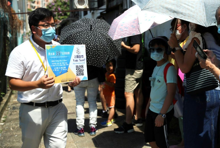 Thousands queued in the intense summer heat at unofficial polling stations across the city hours after police raided an opinion pollster helping to conduct the vote